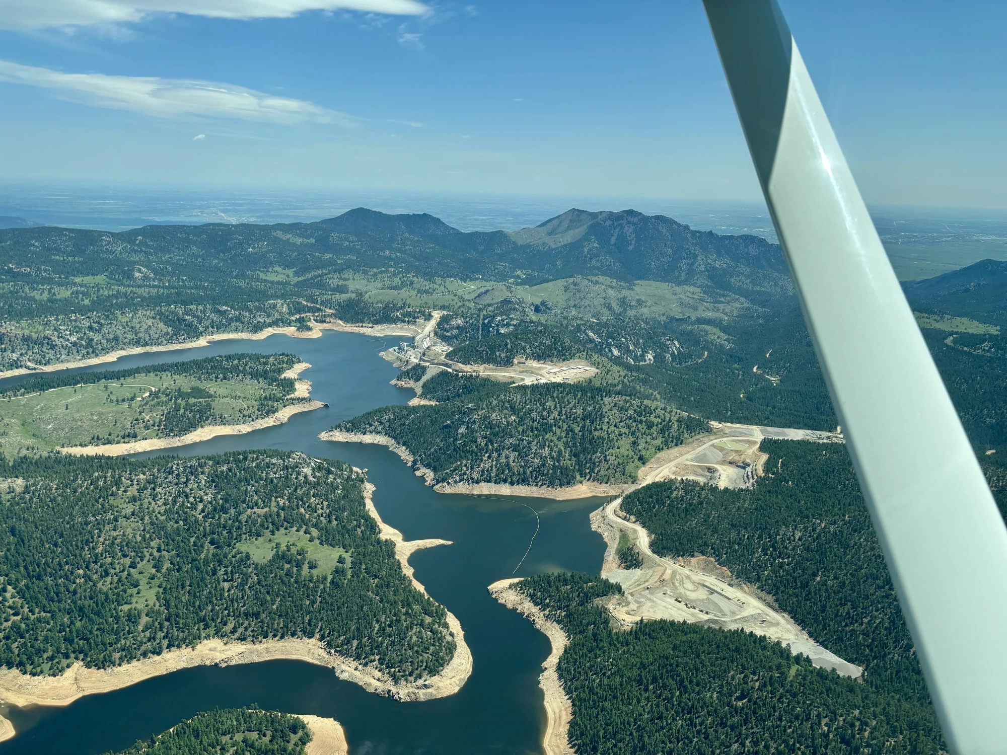 Partially filled reservoir with sand shorelines exposed.