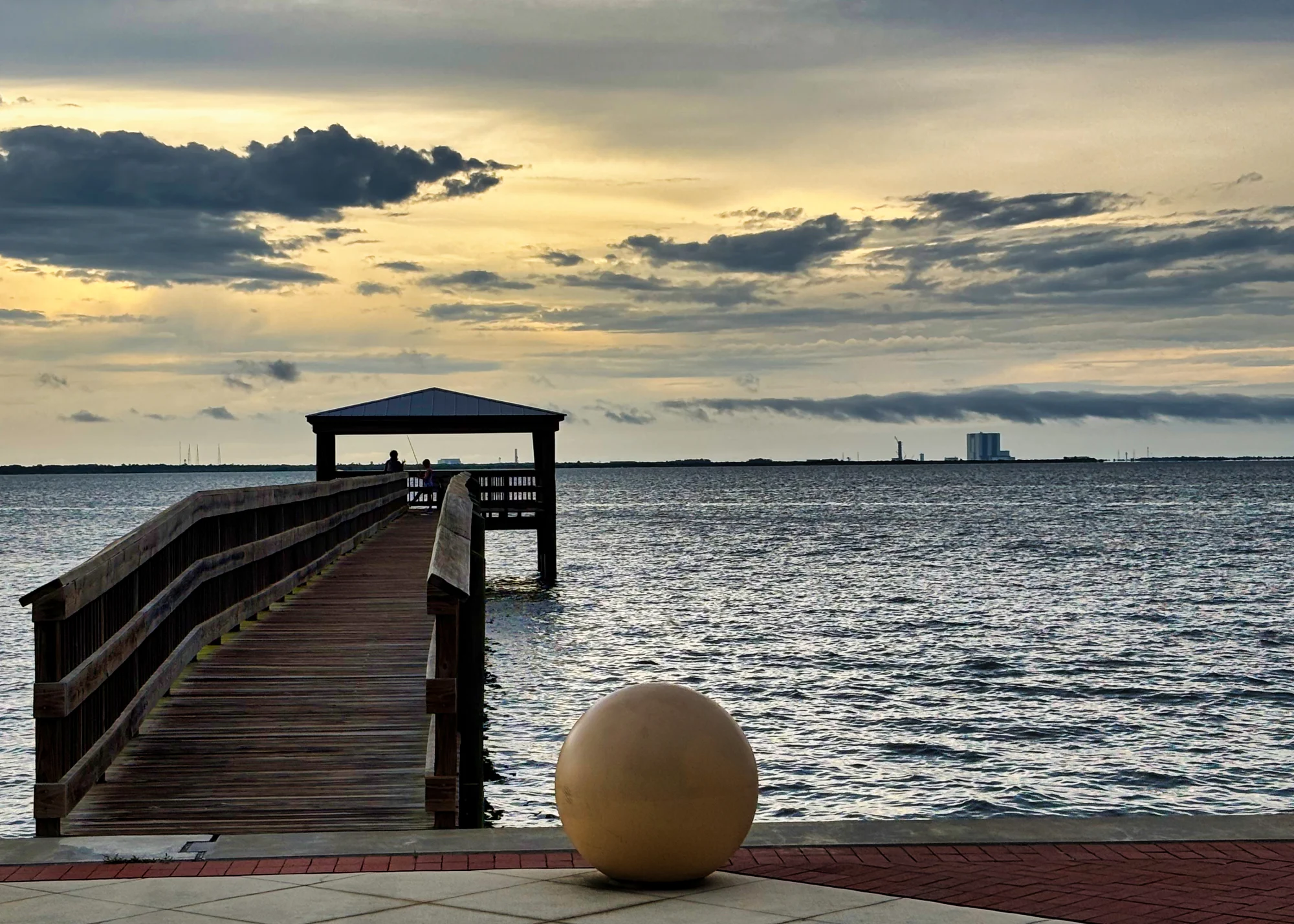 Beach and pier in Titusville, Florida with Kennedy Space Center in the distance.