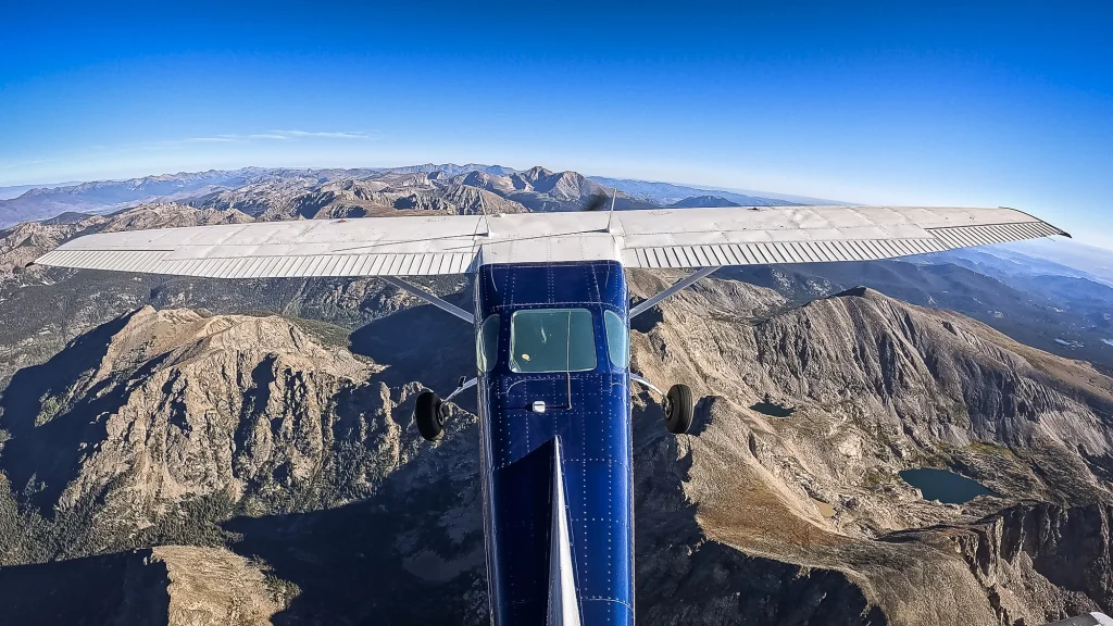 An airplane flies over the peaks of Colorado's Rocky Mountains along the Continental Divide.